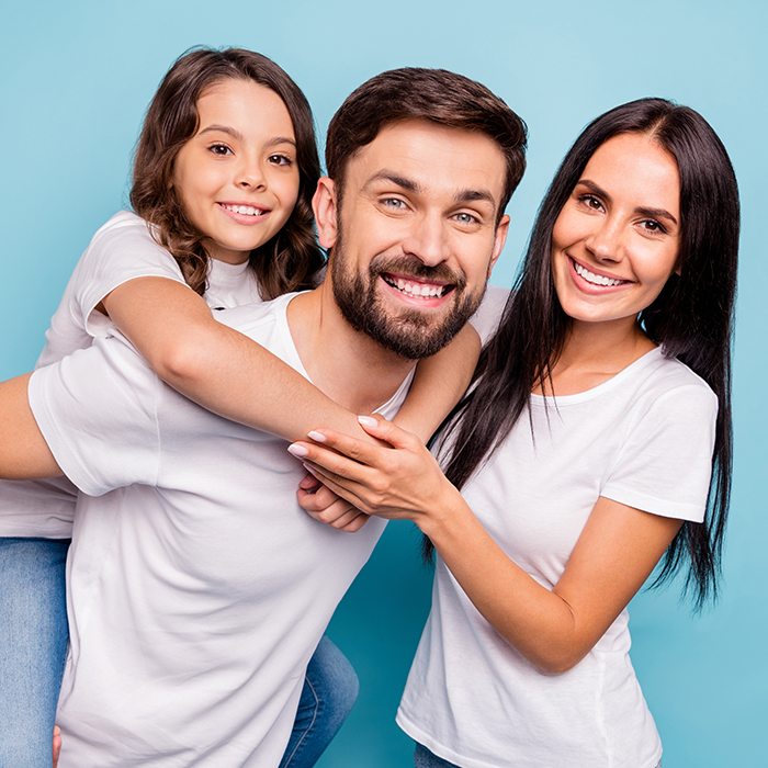 family smiling and posing for prevention dentistry